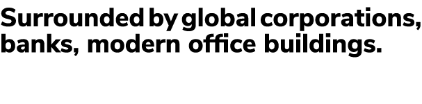 Surrounded by global corporations, banks, modern office buildings.